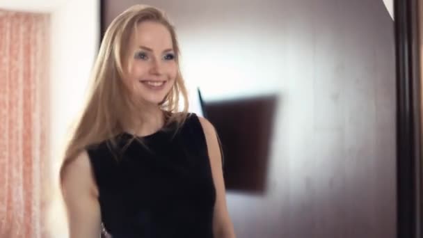 Aantrekkelijke blonde vrolijk meisje op zoek naar de spiegel, lange haren strelen - Video