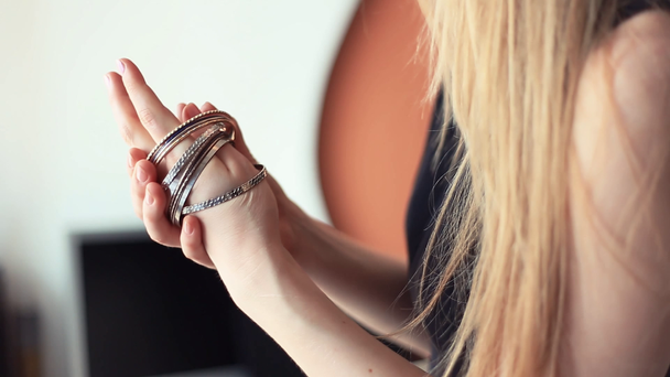 Jeune femme blonde prend bracelets tiroir et le met sur le bras
 - Séquence, vidéo