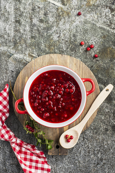 Excellent seasoning for snacks and main dishes. Fresh home made spicy sweet sauce from northern forest berries cranberries in a bowl on a background for serving to meat, to game, to cheeses. Top View. - Fotografie, Obrázek