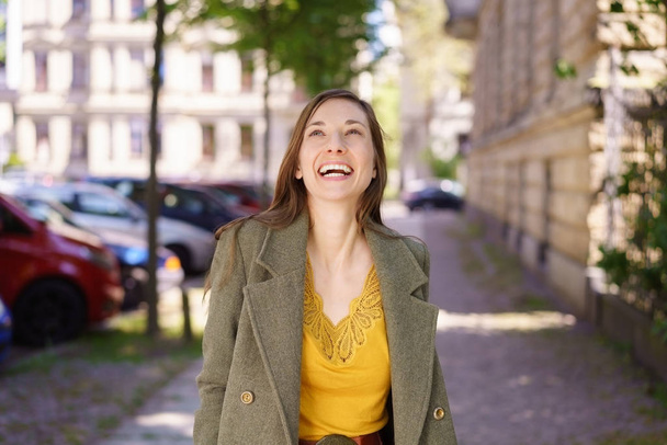 Happy stylish woman walking through town - Zdjęcie, obraz