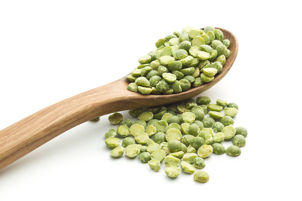 Green split peas in wooden spoon. - Фото, изображение