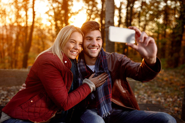 couple having fun outdoors and taking selfie with mobile phone - Фото, зображення