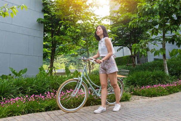 une jeune femme aux cheveux courts avec son vélo
 - Photo, image