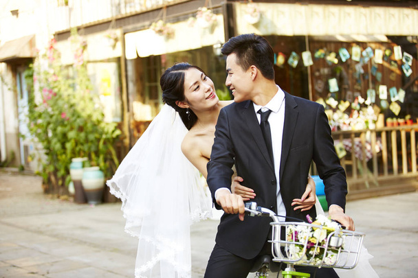 romântico asiático recém-casado montando uma bicicleta
 - Foto, Imagem