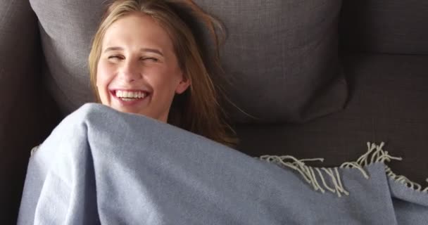 Young blond woman relaxing on the couch - Imágenes, Vídeo