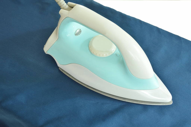 blue automatic electric iron pressing cloth on ironing board - Photo, Image