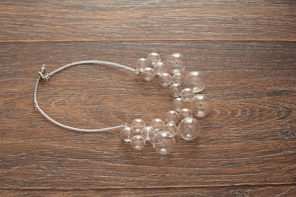 Красивое ожерелье для женщин стекло на деревянном фоне
 - Фото, изображение