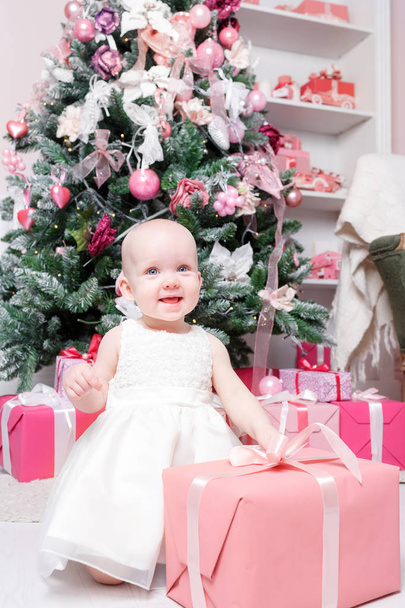 Vánoční večer. Děvčátko sedící a rozbalí dárky. bílé šaty Princezna - Fotografie, Obrázek