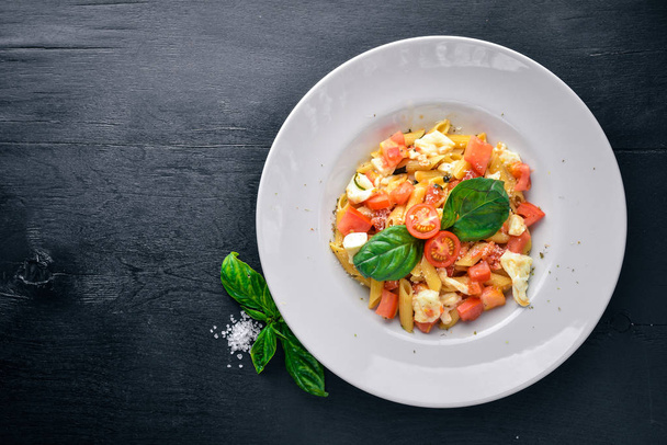 Pasta with vegetables, basil and Parmesan cheese. Italian food. On a wooden background. Top view. Free space for text. - Foto, Imagen