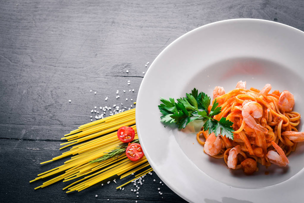 Pasta with shrimp and tomato sauce. Italian traditional food. On a wooden background. Top view. Free space for your text. - Fotoğraf, Görsel