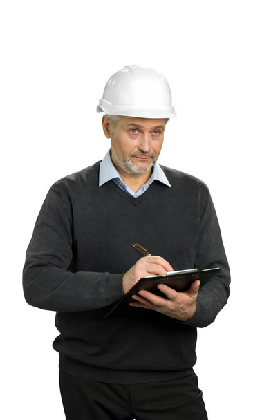 Mature engineer making a note. - 写真・画像