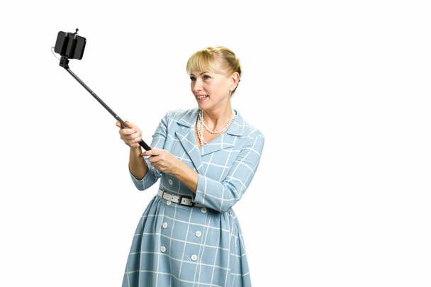 reife Frau mit Selfie-Stick. - Foto, Bild