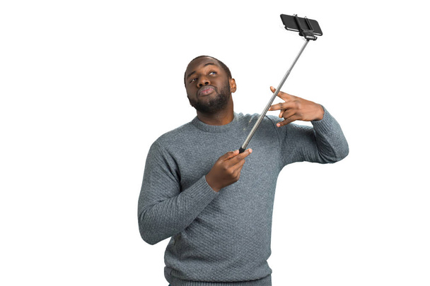 Mooie man nemen selfie met monopod. - Foto, afbeelding
