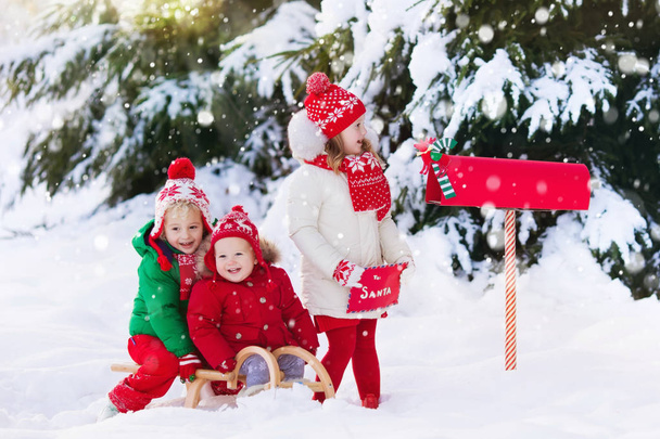 Діти з лист до Санта на Різдво пошти коробка в снігу - Фото, зображення