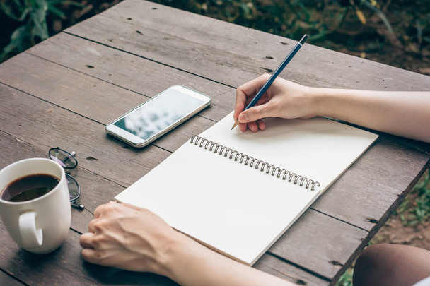 Hipster kobieta ręka notebook papier do pisania w kawiarni. - Zdjęcie, obraz