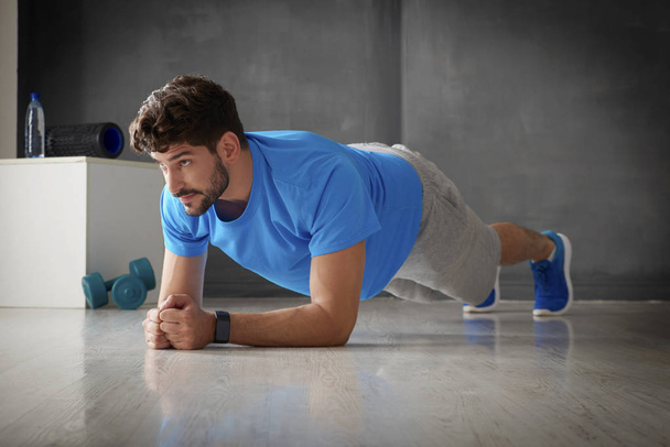 young man planking in gym - Фото, изображение