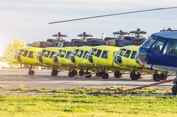 修理メンテナンスのため空港に駐機しているいくつかのヘリコプター - 写真・画像