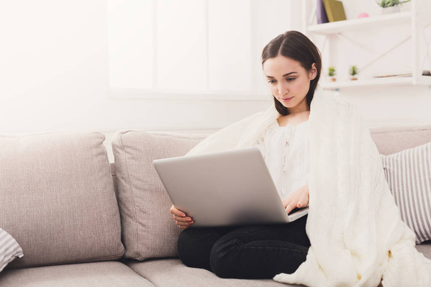 Cozy home. Girl in a plaid with a laptop - Photo, Image
