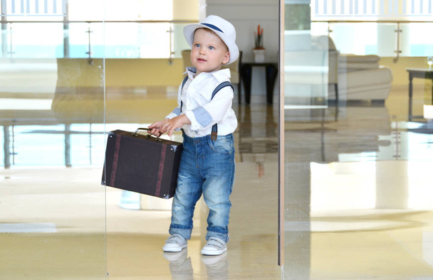 Kisgyermek utazó egy bőrönddel - Fotó, kép