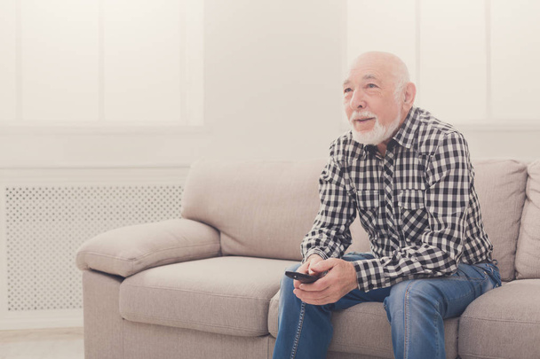 Спокойный пожилой человек смотрит телевизор копия пространства
 - Фото, изображение