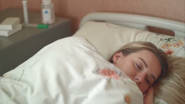 Female patient wakes up in a hospital bed - Filmati, video