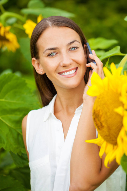 Close-up portrait of beautiful joyful woman with sunflower - Photo, Image
