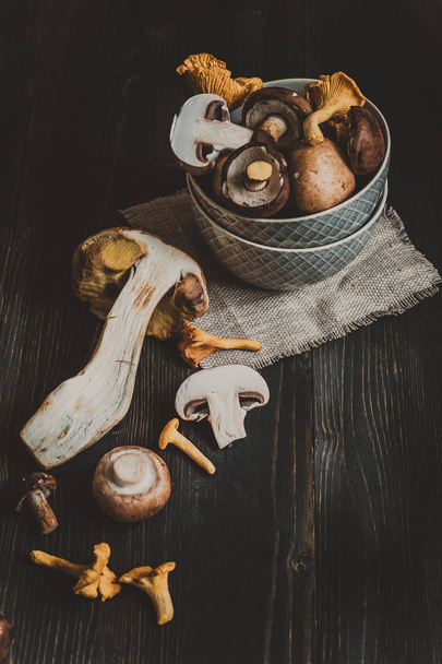 Fresh mixed forest mushrooms on the wooden black table - Foto, immagini