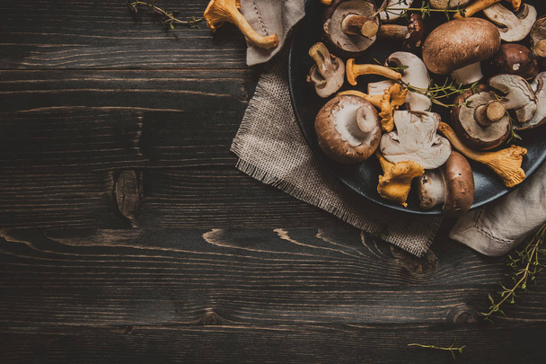 Fresh mixed forest mushrooms on the wooden black table - Valokuva, kuva