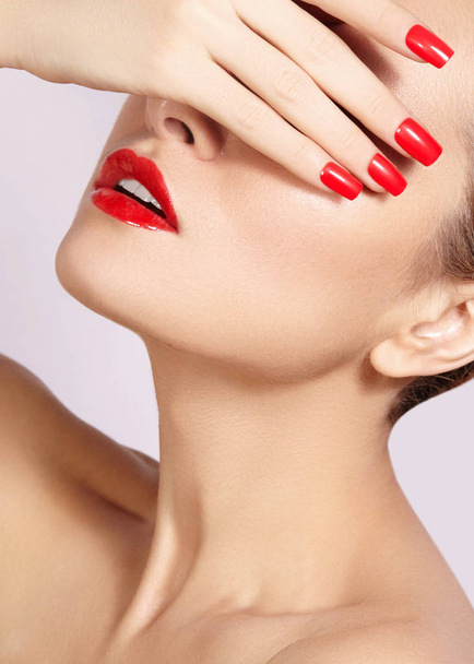 Red lips and bright manicured nails. Sexy open mouth. Beautiful manicure and makeup. Celebrate make up and clean skin - Photo, image