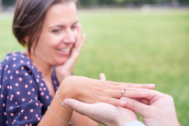 Man brengen een verlovingsring na voorstel buiten - Foto, afbeelding