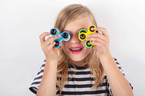 Funny girl playing with four fidget spinners - Foto, Imagem