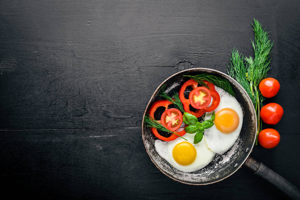 Fried egg with herbs and vegetables in a frying pan. Top view. Free space. - Photo, Image