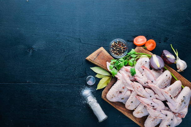 Raw chicken wings with spices. On Wooden surface. Top view. - Фото, зображення