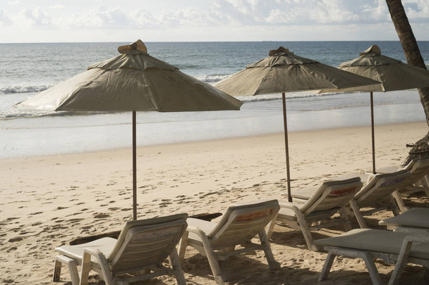 Красивий тропічний пляж з шезлонгами і парасолькою
 - Фото, зображення