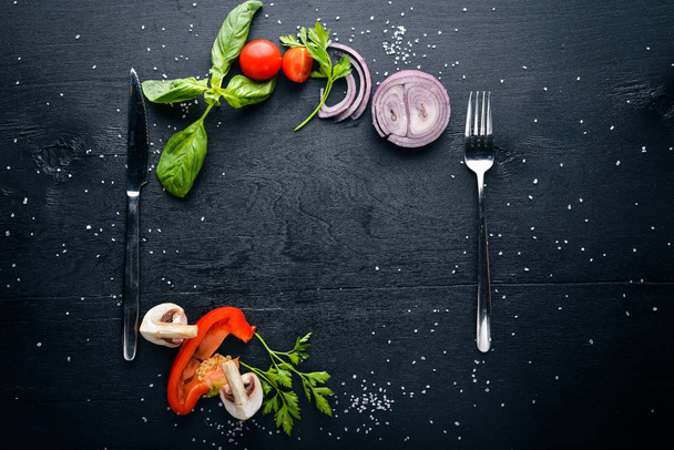 Wooden foam with fresh vegetables and spices. Preparing for cooking. On a black wooden surface. Free space for your text. Top view. - Photo, image