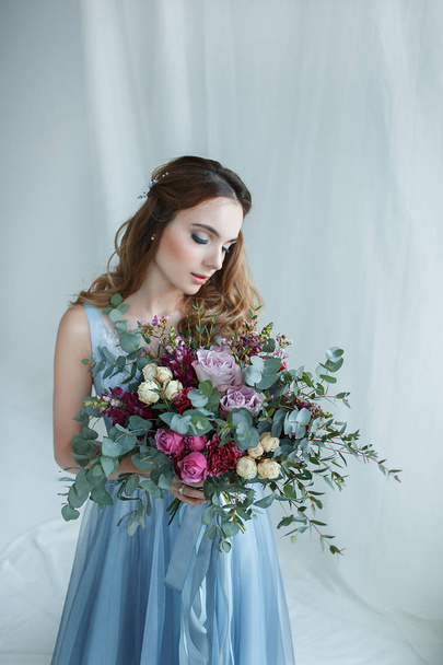 bride in an blue gown with bouquet - Fotó, kép