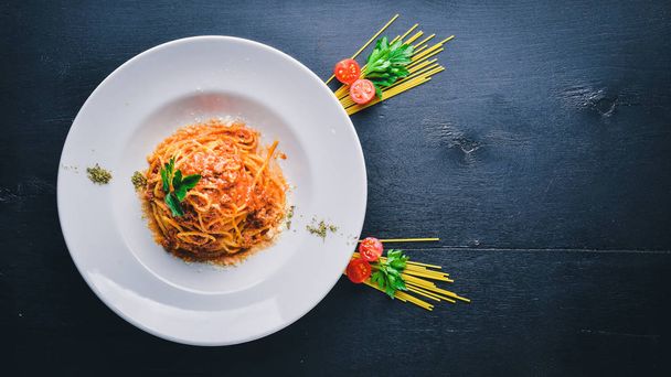 Pasta with tomato sauce and parmesan cheese. Italian traditional food. On a wooden background. Top view. Free space for your text. - Photo, Image