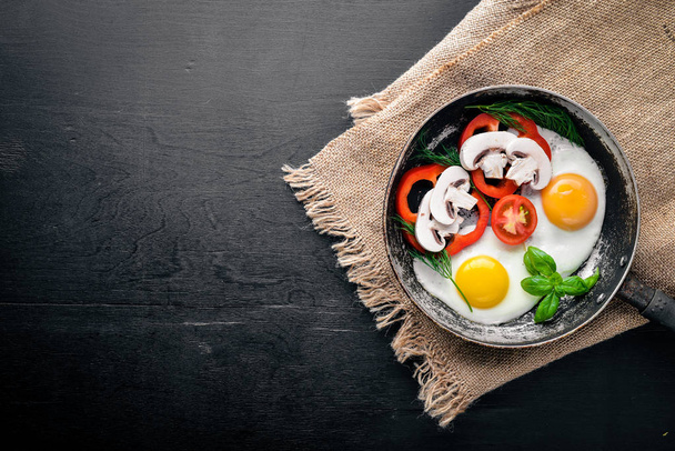 Fried egg with herbs and vegetables in a frying pan. Top view. Free space. - Foto, Imagen