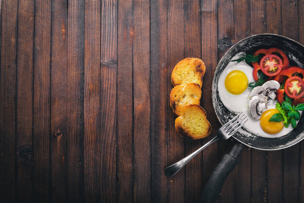 Fried egg with herbs, toast bread and vegetables in a frying pan. Top view. Free space. - Photo, Image