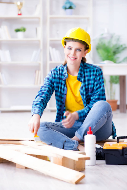 Female repairman carpenter cutting joining wooden planks doing r - Photo, Image