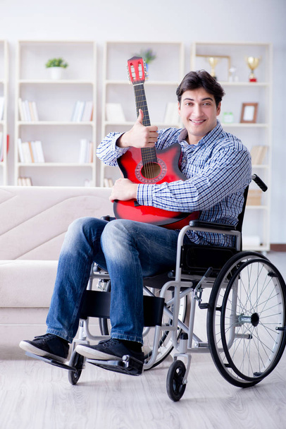 家でギターを弾く障害者 - 写真・画像