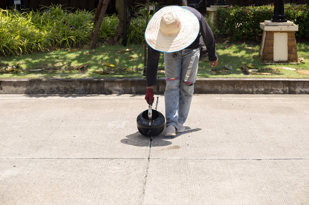 Werknemer is voor weg reparatie asfalt gieten  - Foto, afbeelding