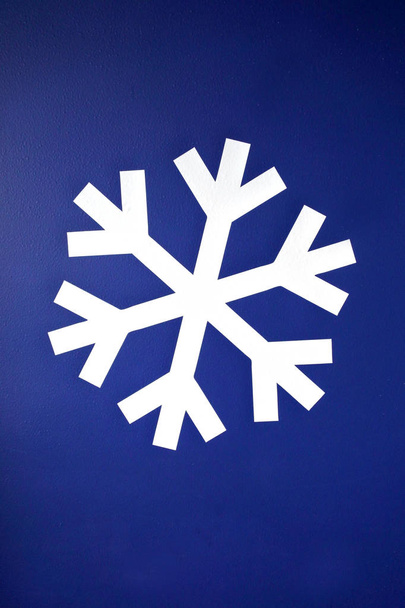 Valkoinen lumihiutale sinisellä pohjalla
 - Valokuva, kuva