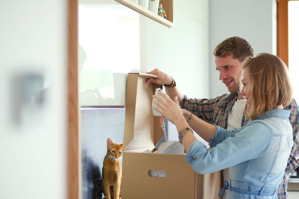 Young couple carrying big cardboard box at new home.Moving house. Young couple - Foto, Imagen