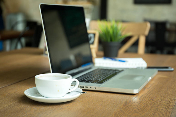 csésze kávé jegyzetfüzet és mobiltelefon kupa, fa íróasztal - Fotó, kép