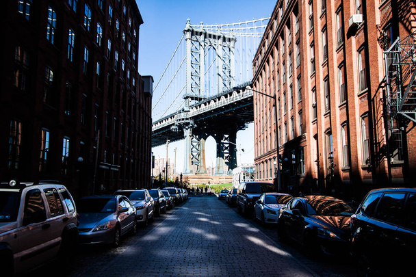 Vista de Brooklyn Bridge em Manhattan, Nova York, de uma rua lateral
 - Foto, Imagem
