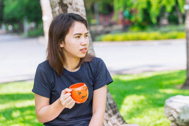 Aasialainen teini tilalla hymiö muki nauttia juo aamulla kahvia
 - Valokuva, kuva
