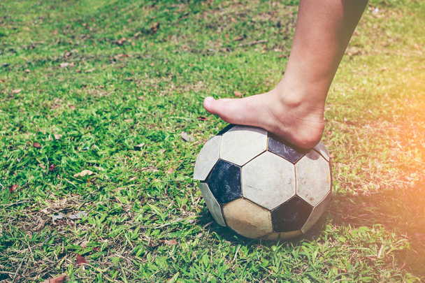 Barefoot football player tread on the soccer ball. Healthy lifestyle concept. - Фото, зображення