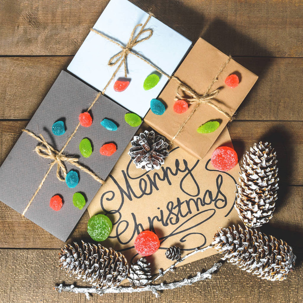 Boxes with gifts, cones, text "Merry Christmas", candies and marmalades - Φωτογραφία, εικόνα