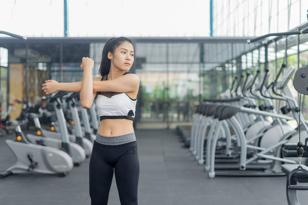 Fitness woman warming and stretching in gym, sport concept - Zdjęcie, obraz